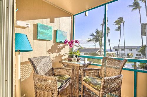 a balcony with chairs and a table with a view of the ocean at Lanai and Community Pool Access Sunny Central Condo in Kailua-Kona