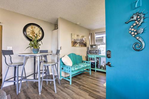a living room with a table and a seahorse wall clock at Lanai and Community Pool Access Sunny Central Condo in Kailua-Kona