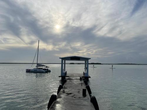 a dock with a boat in the water at Hotel Aldea 19 Bacalar in Bacalar