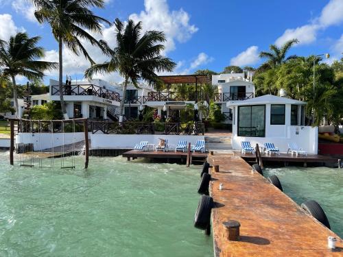 a dock in the water next to a house at Hotel Aldea 19 Bacalar in Bacalar