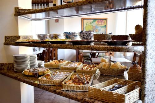 a bakery with bread and pastries on a shelf at Hotel CasaBlanca in Águas de Lindóia