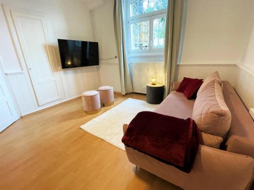 a living room with a couch and a tv at UrbanSuites - Dein Zuhause in Wiesbaden in Wiesbaden