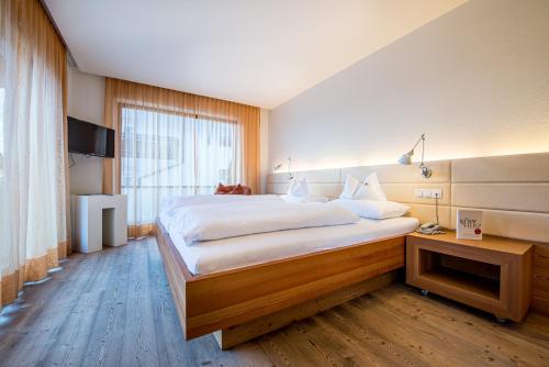 Un ou plusieurs lits dans un hébergement de l'établissement Alphotel Stocker Alpine Wellnesshotel