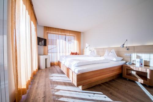 Un ou plusieurs lits dans un hébergement de l'établissement Alphotel Stocker Alpine Wellnesshotel