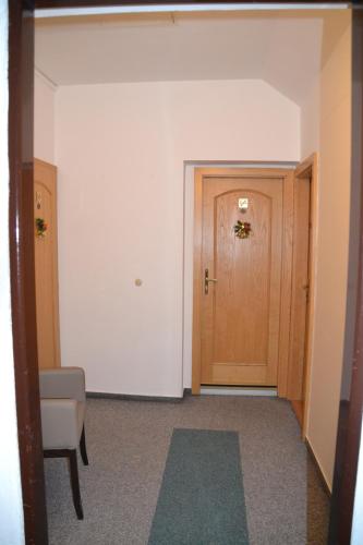 an empty hallway with a door and a chair at Pension U akátu in Prague