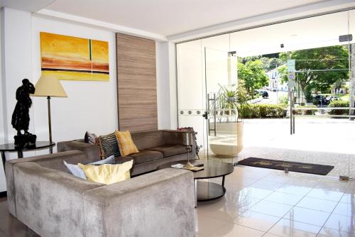 a living room with a couch and a table at Hotel CasaBlanca in Águas de Lindóia