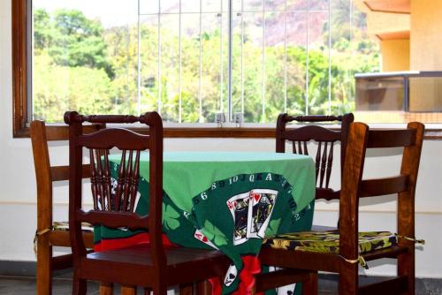 a table with a green table cloth on two chairs at Hotel CasaBlanca in Águas de Lindóia