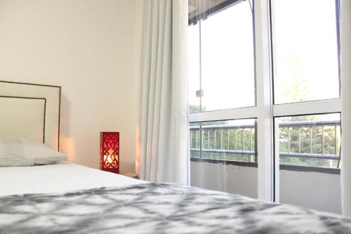 sypialnia z łóżkiem i dużym oknem w obiekcie APTO completo para sua família! w mieście Cascavel