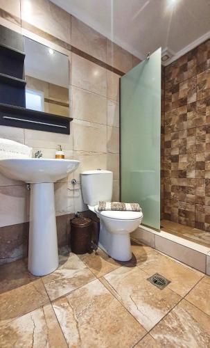 a bathroom with a toilet and a sink at Villa Pirofani in Sarti