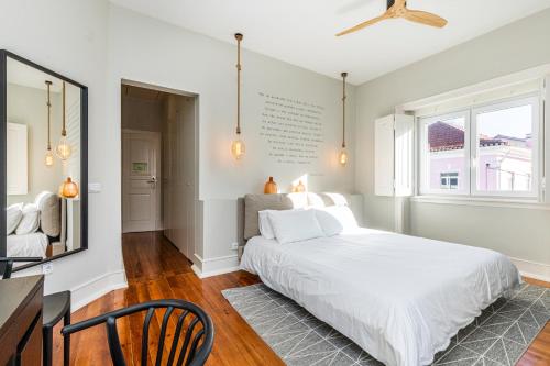 a bedroom with a white bed and a dining room at Sweet Spot @ Beach in Estoril