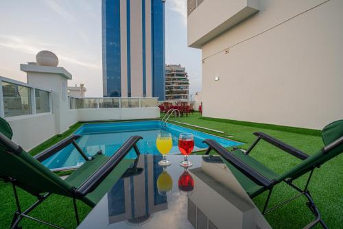 Vista City Hotel في دبي: كأسين من النبيذ يجلسون على طاولة على شرفة
