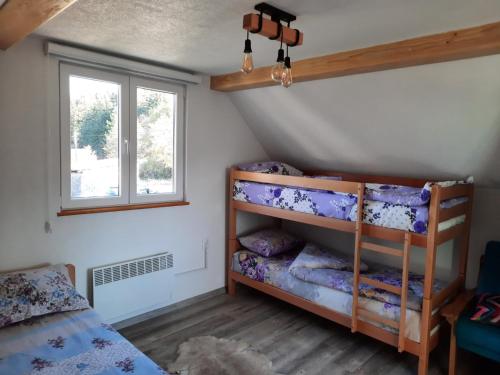 a bedroom with bunk beds and a window at Deda Simina vikendica in Pale