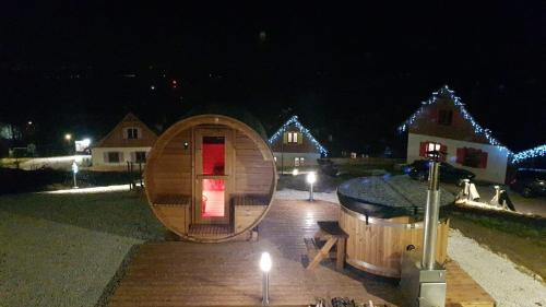 a large wooden hobbit house with a lit up room at night at Kolorowe Karkonosze in Przesieka