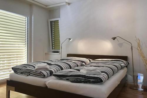 Bett in einem Zimmer mit zwei Lampen in der Unterkunft Residenz Ambassador A11 in Leukerbad