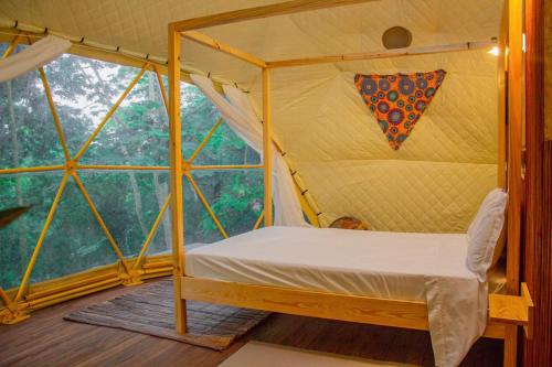 a room with a canopy bed in a tent at Eden Valley Ecolodge and Farming in Madalena