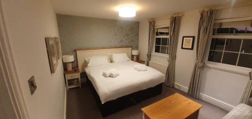 
a bedroom with a white bed and white walls at Penhelig Arms in Aberdyfi
