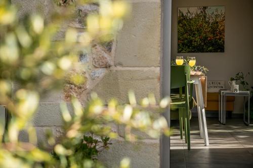 a dining room with a table with a green chair at Olive Lemon Biophilic House & Lush Forest Garden in Vamos