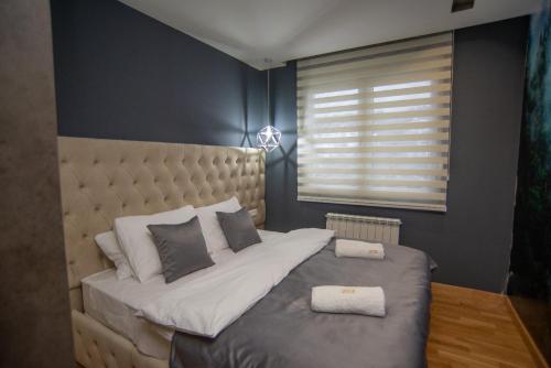 a bedroom with a large bed and a window at Modern Mountain Apartman 202 in Kolašin