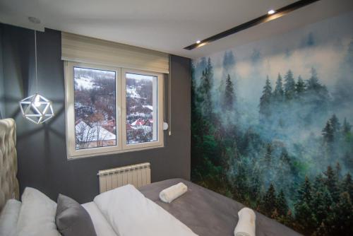 a bedroom with a large painting on the wall at Modern Mountain Apartman 202 in Kolašin