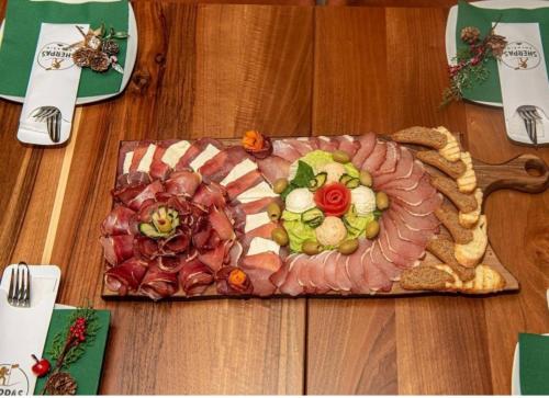a plate of food on a wooden table at Modern Mountain Apartman 202 in Kolašin