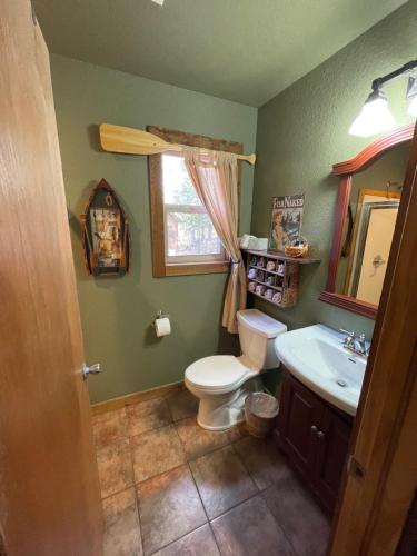 a bathroom with a toilet and a sink and a window at Eureka Sunset Cabins in Eureka Springs