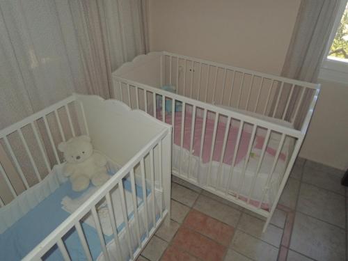 two baby cribs with a teddy bear in a room at Archipelagos Sunset Apartments in Posidhonía