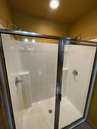 a shower with a glass enclosure in a bathroom at Eureka Sunset Cabins in Eureka Springs
