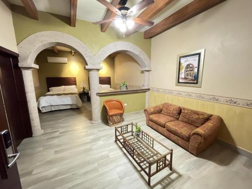 a living room with a bed and a couch at Hotel Real de los Alamos in Álamos