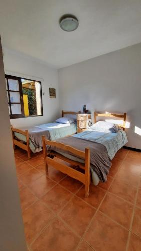 1 dormitorio con 2 camas y ventana en CasAmarilla La Barra, en Punta del Este