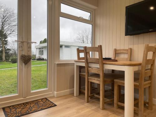a dining room with a table and chairs and a window at Galwad-Y-Môr in Haverfordwest