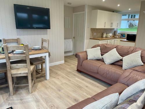 a living room with a couch and a table and a kitchen at Galwad-Y-Môr in Haverfordwest