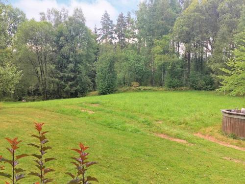 a large green field with trees in the background at 4 person holiday home in R RVIK in Rörvik