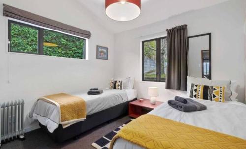 a bedroom with two beds and a window at Fantastic Views, Close to Town 2 Bedroom Apartment in Queenstown