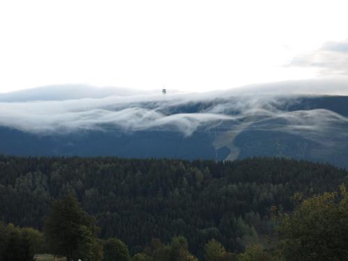 a view of a valley of clouds and trees at Naproti Klínovci in Jáchymov