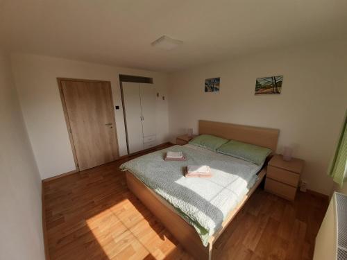 a small bedroom with a bed and a wooden floor at Naproti Klínovci in Jáchymov