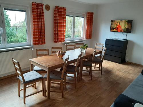 a dining room with a wooden table and chairs at Naproti Klínovci in Jáchymov