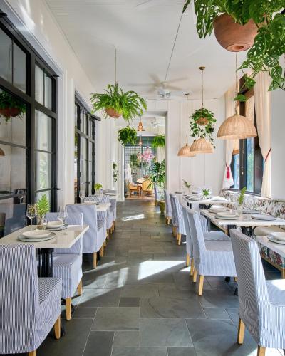 a restaurant with tables and chairs and potted plants at Virgin Hotels New Orleans in New Orleans