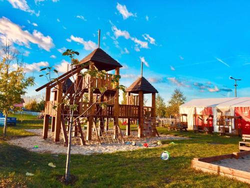 einen Holzspielplatz in einem Park mit Zelt in der Unterkunft Apollo Inn in Velence