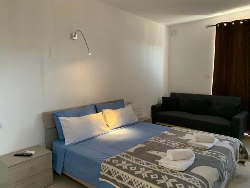 a bedroom with a bed with a couch and a chair at Mon-Chery in San Ġwann