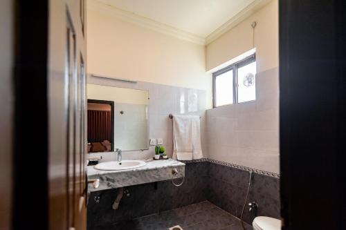 ein Bad mit einem Waschbecken und einem Spiegel in der Unterkunft Shelton's Rezidor Islamabad in Islamabad