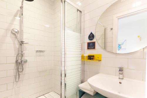 a white bathroom with a shower and a sink at The Caravan in Thessaloniki