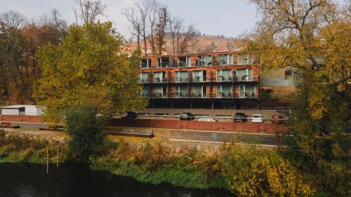 a building with cars parked in front of a river at Hotel Split in Kadaň