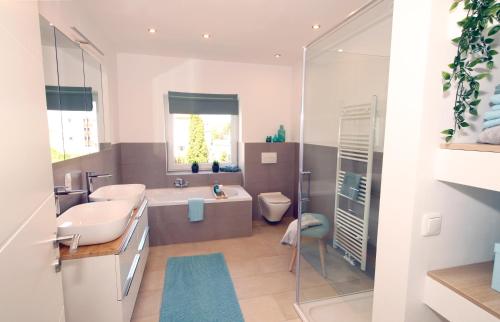 ein Badezimmer mit einer Badewanne, einem Waschbecken und einem WC in der Unterkunft Ferienhaus Westermann, Businesswohnung, Monteurzimmer in Salzgitter