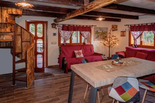een woonkamer met rode meubels en een houten tafel bij La casa dei funghi in Pedara