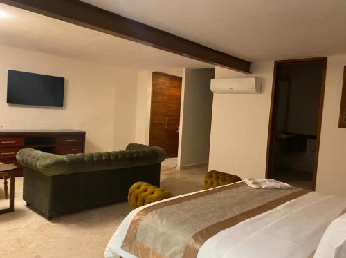 a bedroom with a bed and a couch and a television at Real Hispano in Valladolid