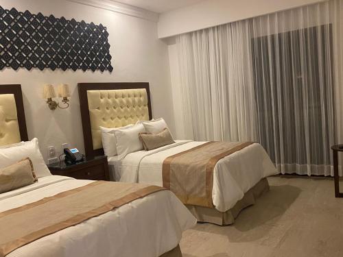 a hotel room with two beds and a window at Real Hispano in Valladolid