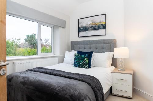 - une chambre avec un grand lit et une fenêtre dans l'établissement Relaxation by Olauda SA - 3 Bed House with Free Parking, à Bristol