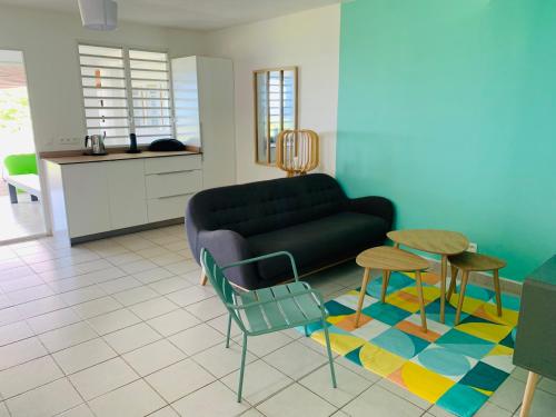 a living room with a couch and a table and chairs at Villa Fresh&Cosy Trois-Ilets 3 étoiles in Les Trois-Îlets