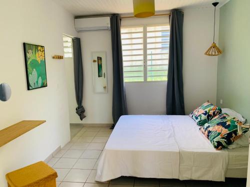 1 dormitorio con cama y ventana en Villa Fresh&Cosy Trois-Ilets 3 étoiles, en Les Trois-Îlets