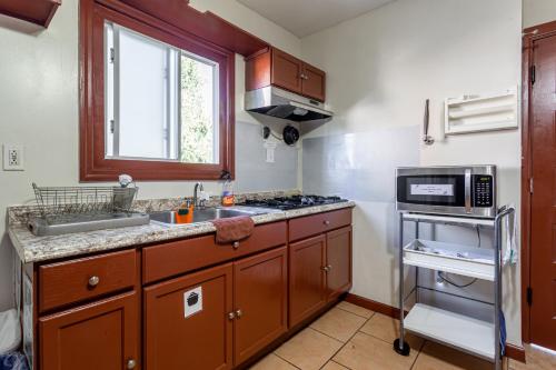 a small kitchen with a sink and a microwave at 1 Bus Stop To NYC-Hot Tub-EWR Airport-Free Parking in Hillside
